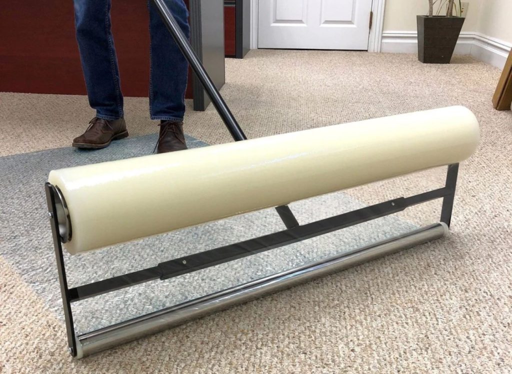 A man uses plastic to clean the floor, emphasizing a protection and prevention service located in Fresno, CA.